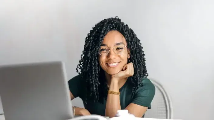 A woman sitting at a table with her laptop