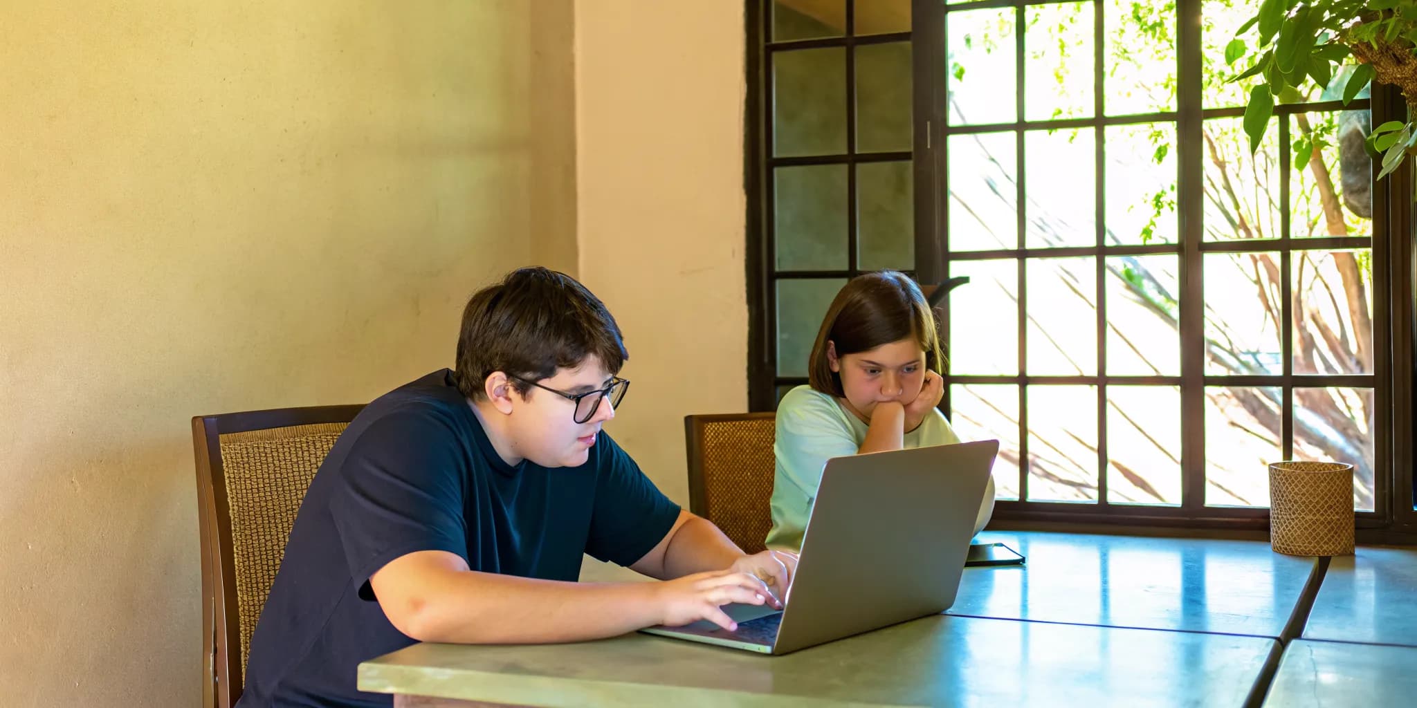 Students work with a Digital SAT tutor on a laptop to improve their scores.